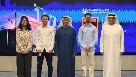 With the team in front of a Khalifa University display